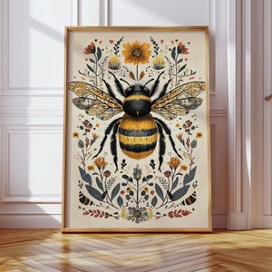Può includere: Una stampa artistica incorniciata con un'illustrazione dettagliata di un'ape a strisce gialle e nere, circondata da elementi floreali nei toni dell'arancione, del giallo e del verde. L'opera d'arte ha un'estetica vintage ed è su sfondo color crema.
