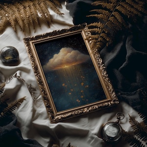 May include: A framed painting with a gold ornate frame depicts a cloud with golden light and falling flowers against a dark blue starry sky. The painting is set on a white cloth with gold fern leaves and a dark gray fabric.