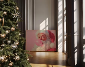 May include: A framed painting of Santa Claus blowing a bubblegum bubble. The painting has a pink background and is displayed on a wooden floor next to a decorated Christmas tree. The room has a neutral color palette.