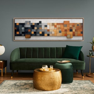 May include: A contemporary living room with a dark green velvet sofa, a gold hammered metal coffee table, and a framed abstract artwork with a geometric design. The room is decorated with a gold lamp and side table.