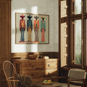 May include: A framed art print featuring four stylized figures in cowboy attire. Each figure is depicted in a different color scheme, with hats, jackets, and pants in shades of red, blue, orange, and green. The artwork is displayed in a room with wooden furniture.