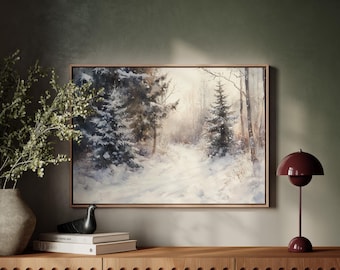 Puede incluir: Pintura enmarcada de un paisaje nevado con altos árboles de hoja perenne y un camino. La obra de arte se exhibe sobre un mueble de madera, junto a una lámpara de mesa burdeos y objetos decorativos.