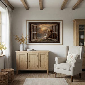 Puede incluir: Una obra de arte enmarcada representa un león y un cordero descansando juntos, vistos a través de una ventana abierta. La habitación cuenta con paredes claras, pisos de madera y un mueble de madera. Un sillón beige con un cojín floral está cerca.