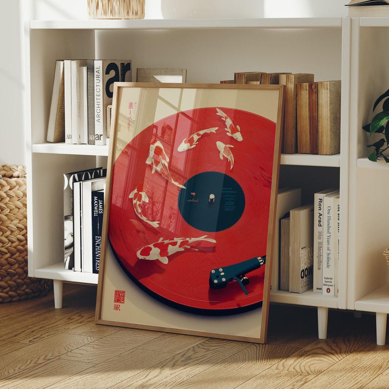 Puede incluir: Una impresi&oacute;n art&iacute;stica enmarcada con un dise&ntilde;o de vinilo rojo con ilustraciones de peces koi. La obra de arte tiene un marco de madera y se exhibe en una estanter&iacute;a blanca con libros y objetos decorativos. La impresi&oacute;n tiene texto japon&eacute;s.