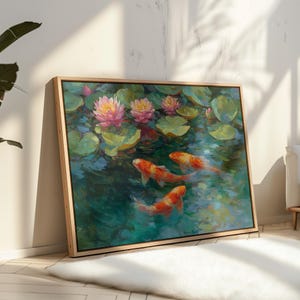 May include: A framed painting depicts a pond scene with koi fish and water lilies. The artwork features orange and white koi swimming in teal water, surrounded by green lily pads and pink and yellow water lilies. The frame is a light wood color.