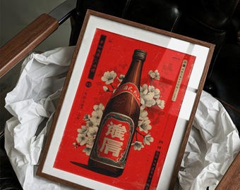 May include: Framed vintage-style print featuring a brown bottle with Japanese text and white cherry blossoms on a red background. The print is in a wooden frame and rests on white paper, placed on a black leather chair.
