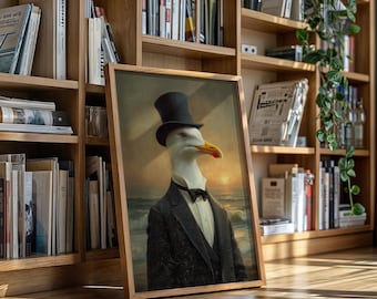 May include: Framed artwork featuring a seagull in a black top hat and suit, with a bow tie. The seagull is set against a seascape background with a sunset. The artwork is in a wooden frame and leans against a bookshelf.