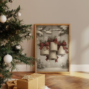 May include: A framed print depicts four cylindrical objects adorned with red plaid bows and sprigs of greenery, hanging against a snowy winter landscape. The artwork is in a sepia tone, evoking a vintage aesthetic, and is set against a neutral wall.