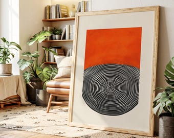 May include: A framed abstract art print featuring a vibrant orange rectangle above a black and white spiral design. The artwork is displayed in a light wooden frame, adding a touch of warmth to the modern design. The print is set against a neutral background.