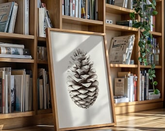 Może przedstawiać: Oprawiona czarno-biała grafika szyszki. Grafika jest prezentowana w jasnej drewnianej ramie i opiera się o półkę z książkami. Szyszka jest szczegółowa z cieniowaniem, tworząc realistyczny wygląd.