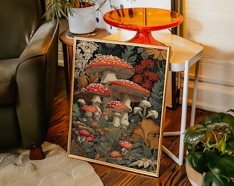 May include: A framed art print featuring a detailed illustration of several red-capped mushrooms with white spots, set amidst lush green foliage and other forest elements. The artwork has a gold frame and is displayed on a wooden floor.