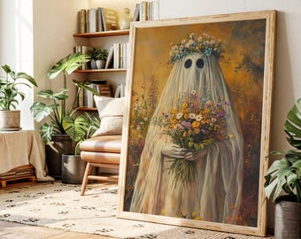 May include: A framed artwork depicts a ghost-like figure draped in white fabric, holding a bouquet of colorful flowers. The figure wears a floral crown. The artwork has a warm, golden background and is displayed in a room with plants and books.