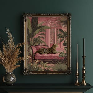 May include: A framed art print depicts a leopard resting on a pink chaise lounge amidst lush tropical foliage. The artwork features a detailed gold frame and a pink and green color palette, creating a vintage aesthetic. The print is displayed on a dark green wall.