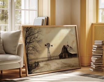 Puede incluir: Una impresión enmarcada en tonos sepia de una escena rural invernal. La obra de arte representa un granero, un molino de viento y una valla en un paisaje nevado. La impresión está en un marco de madera clara, apoyada contra una pared.