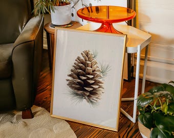 Może przedstawiać: Oprawiony botaniczny nadruk przedstawiający szczegółową ilustrację szyszki z zielonymi igłami. Grafika jest umieszczona na neutralnym tle i oprawiona w złotą ramę. Nadruk jest eksponowany na drewnianej podłodze.