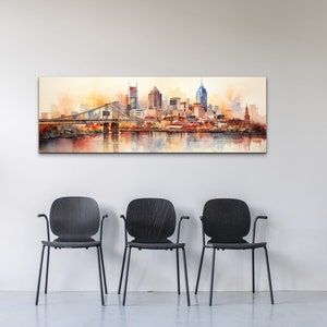 Op de afbeelding: Een aquarel schilderij van een skyline met een brug en een rivier op de voorgrond. De gebouwen zijn geschilderd in tinten oranje, bruin en geel, met een paar blauwe accenten. De lucht is zachtgeel en het water is lichtblauw.