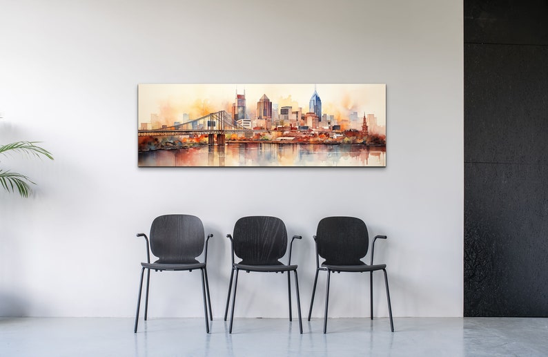 Op de afbeelding: Een aquarel schilderij van een skyline met een brug en een rivier op de voorgrond. De gebouwen zijn geschilderd in tinten oranje, bruin en geel, met een paar blauwe accenten. De lucht is zachtgeel en het water is lichtblauw.