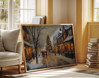 Puede incluir: Una pintura enmarcada representa una escena navideña nevada. Un árbol de Navidad decorado se encuentra en el centro de una calle bordeada de edificios. La pintura está en un marco de madera y está apoyada contra una pared.