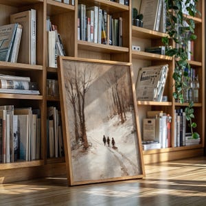 May include: A framed landscape painting depicts a snowy path through a forest, with three figures walking away from the viewer. The artwork is in a light wooden frame and is leaning against a bookshelf filled with books.