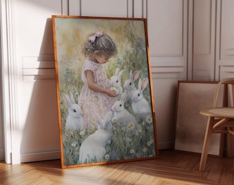 Puede incluir: Una impresión en acuarela enmarcada representa a una niña con un vestido rosa rodeada de conejos blancos en un campo de margaritas. La obra de arte tiene una paleta de colores cálidos y está enmarcada en un marco de madera, creando una escena caprichosa y pastoral.