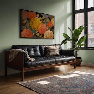Könnte beinhalten: Ein Wohnzimmer mit einem schwarzen Ledersofa, Holzrahmen und einem floralen Kunstwerk. Ein gemusterter Teppich und eine Topfpflanze sind ebenfalls vorhanden. Das Kunstwerk zeigt große, farbenfrohe Blumen.