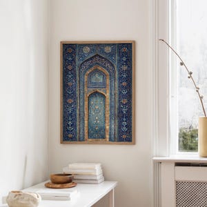 May include: Framed wall art featuring a detailed, ornate design in shades of blue, gold, and teal. The artwork depicts an arched doorway with intricate patterns and calligraphy. The wooden frame complements the artwork's colors, creating a decorative piece.