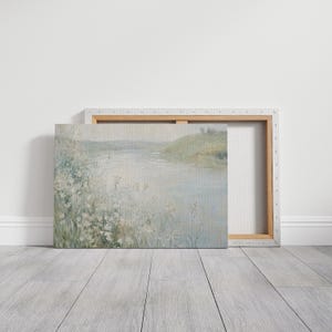 K&ouml;nnte beinhalten: Ein Gem&auml;lde, das eine Flussszene mit einem grasbewachsenen Ufer und wei&szlig;en Blumen im Vordergrund zeigt. Das Wasser ist hellblau und der Himmel ist hellgrau.