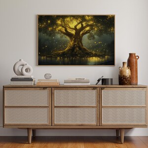Puede incluir: Una impresi&oacute;n enmarcada muestra un &aacute;rbol luminoso con una copa dorada y luces brillantes, sobre un fondo oscuro. La obra de arte se exhibe sobre un mueble de madera con paneles de puerta tejidos, adornado con jarrones y libros.