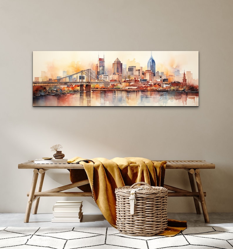 Op de afbeelding: Een aquarel schilderij van een skyline met een brug op de voorgrond. De gebouwen zijn geschilderd in tinten bruin, oranje en geel, en het water is lichtblauw. De lucht is lichtgeel.
