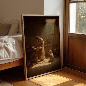 May include: A framed print of a painting depicting a man working at a wooden workbench, with a young boy kneeling nearby. The scene is illuminated by a shaft of light, creating a dramatic contrast of light and shadow. The artwork is displayed on a wooden floor.