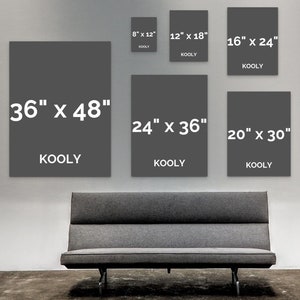 Puede incluir: Una pared con ocho impresiones de lienzo grises de diferentes tama&ntilde;os con el texto "KOOLY" impreso en cada una. Las impresiones est&aacute;n dispuestas en una cuadr&iacute;cula en una pared blanca. Un sof&aacute; gris est&aacute; en primer plano.