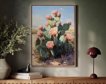 Könnte beinhalten: Ein gerahmtes Gemälde eines Feigenkaktus mit rosa Blüten. Der Kaktus steht vor einem blauen Himmel mit weißen Wolken. Das Gemälde ist im rustikalen Stil gehalten.
