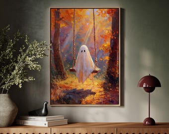 May include: A framed art print depicts a white ghost on a swing in a sunlit autumn forest. The artwork features warm colors of orange, yellow, and brown, with a wooden frame. The ghost has two black eyes and is draped in a white sheet.