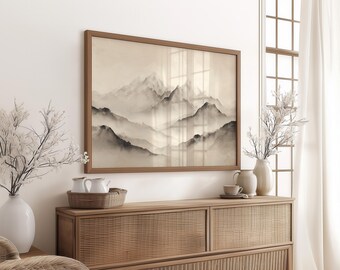 May include: A framed landscape art print depicting a misty mountain range in shades of gray and beige. The artwork hangs above a wooden cabinet with decorative vases and a woven tray. The room is decorated in neutral tones.