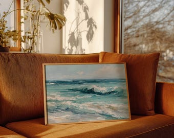 May include: A framed artwork depicting ocean waves in shades of turquoise and white. The painting is set in a light wooden frame and rests on a rust-colored corduroy sofa. The scene is illuminated by natural light.