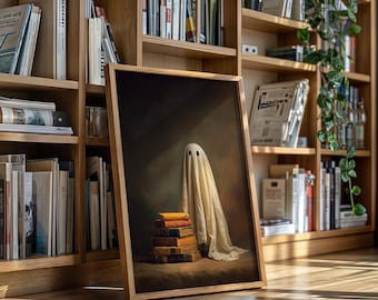 May include: A framed artwork featuring a ghost draped in a white sheet with two black eye holes. The ghost stands atop a stack of books with orange and brown covers. The artwork is set against a dark background.