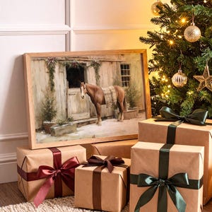 Puede incluir: Una pintura enmarcada de un caballo en un establo, con una manta, se exhibe cerca de regalos envueltos con cintas. Un árbol de Navidad con adornos y luces está en el fondo. Los regalos están envueltos en papel marrón con cintas burdeos, marrones y verdes.