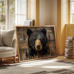 May include: A framed print of a black bear's head, set against a backdrop of wooden planks. The bear's fur is black, with brown and tan highlights around the face. The artwork is presented in a natural wood frame, creating a rustic aesthetic. The image is suitable for home decor.