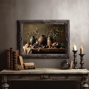 Puede incluir: Una pintura enmarcada de naturaleza muerta que representa una mesa de madera con varias frutas, jarrones y follaje. La pintura está en un marco oscuro y adornado. Dos velas encendidas en candelabros negros y una pila de libros están sobre una mesa de madera.