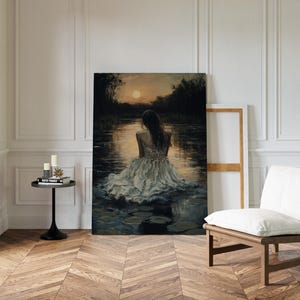 May include: A painting of a woman in a white dress sitting in a body of water with lily pads. The water is dark blue and the sky is a soft orange. The woman is facing away from the viewer and her hair is long and dark.
