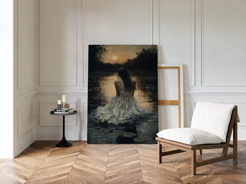 May include: A painting of a woman in a white dress sitting in a body of water with lily pads. The water is dark blue and the sky is a soft orange. The woman is facing away from the viewer and her hair is long and dark.