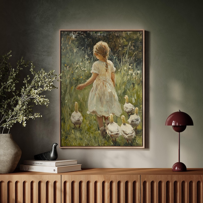 May include: A painting of a young girl in a white dress walking through a field of green grass and wildflowers, followed by a group of white ducklings.