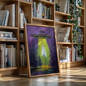 May include: A framed art print depicts a UFO beaming a light onto a ghost in a forest. The artwork features a purple sky, green and purple trees, and a yellow beam of light. The UFO is purple and silver.