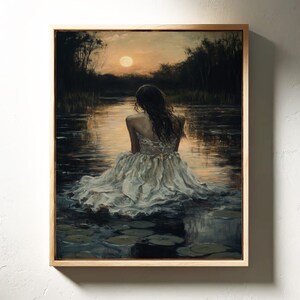 May include: A woman in a white dress sits on the edge of a lake at sunset. The water is calm and reflects the light of the setting sun. The woman's back is to the viewer, and she is looking out at the water.