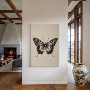 Pu&ograve; includere: Un disegno in bianco e nero di una farfalla su uno sfondo color crema.