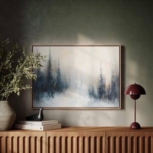 May include: A framed painting of a foggy forest scene with tall, dark trees in the background. The painting is hanging on a wall above a wooden cabinet with a red lamp on the right side.