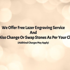 May include: Text on a blurred background reads: "We Offer Free Lazer Engraving Service And We Also Change Or Swap Stones As Per Your Choice (Additinal Charges May Apply)". The text is in black against a light beige background with soft, out-of-focus white circles.