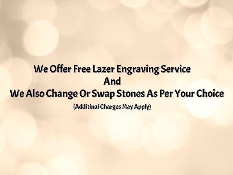 May include: Text on a blurred background reads: "We Offer Free Lazer Engraving Service And We Also Change Or Swap Stones As Per Your Choice (Additinal Charges May Apply)". The text is in black against a light beige background with soft, out-of-focus white circles.