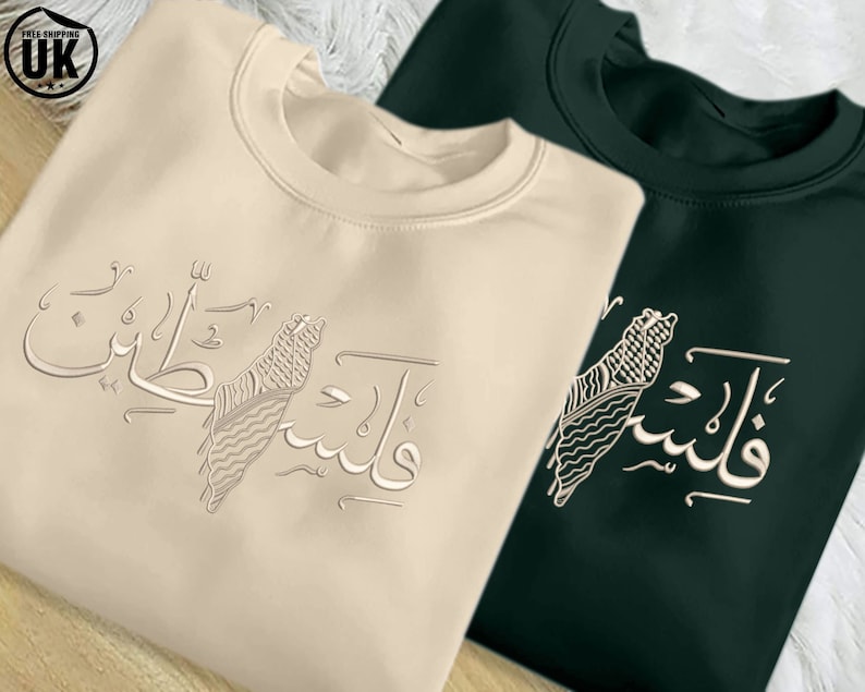 May include: Two sweatshirts with a graphic design of a stylized map of Palestine with Arabic text that reads "Palestine" in English. The sweatshirts are beige and dark green.