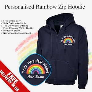 Könnte beinhalten: Ein marineblauer Kapuzenpullover mit Reißverschluss und einem gestickten Regenbogen-Design. Das Design enthält den Text "Your Hospital Name" und "Your Name".